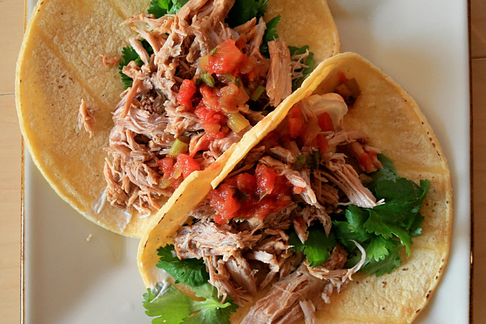 Pork carnitas tacos with crisp-edged pork, onion, cilantro and lime