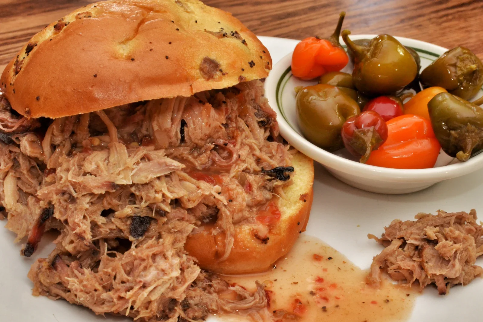 Tender shredded pulled pork coated with reduced cooking juices on a serving platter